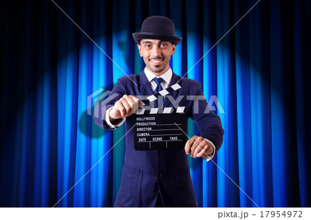 Man with movie clapper on curtain background Man with movie clapper on curtain background 17954972