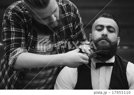 barber shaves a bearded man barber shaves a bearded man 17955110