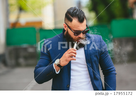 man with a beard smokes electronic cigarette man with a beard smokes electronic cigarette 17955172