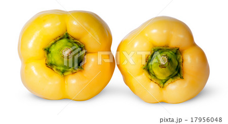 Two yellow bell peppers lying beside 17956048