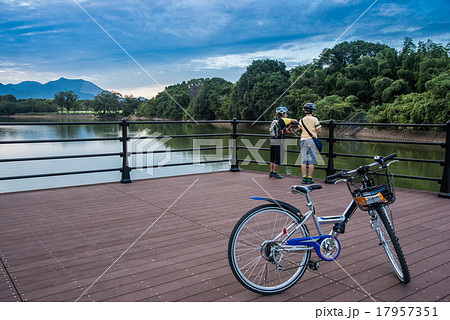 三重県 北勢中央公園の池で釣りをする少年と自転車の写真素材