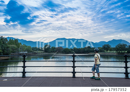 三重県 北勢中央公園の池で釣りをする少年の写真素材