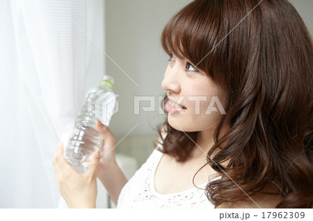 室内でミネラルウォーターを飲む女性 17962309