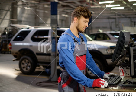 Specialist near car diagnostic pc in a workshop Specialist near car diagnostic pc in a workshop 17973329