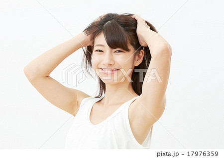 髪を搔き上げる女性の写真素材