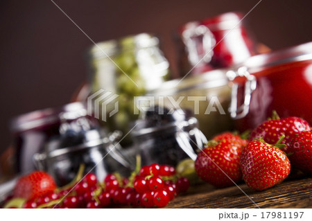 Jams in glass jars with wood and fresh berries 17981197
