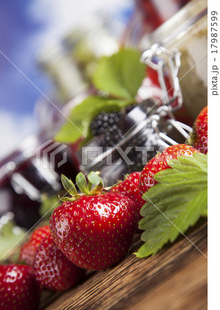 Jams in glass jars with wood and fresh berries 17987599