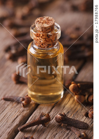 Oil of cloves in a glass bottle on a table macro 17988766