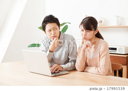 パソコンの画面を見て悩む男女カップル 17991539