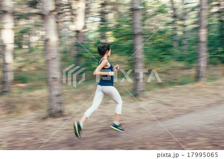 Young woman running on a rural road  in  forest 17995065