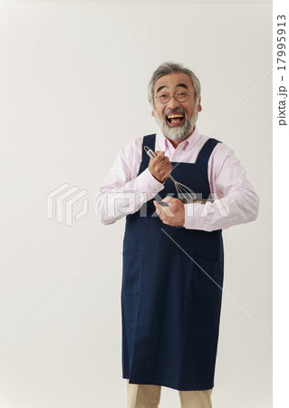 エプロン姿で泡立て器とボールを持つシニア男性 17995913