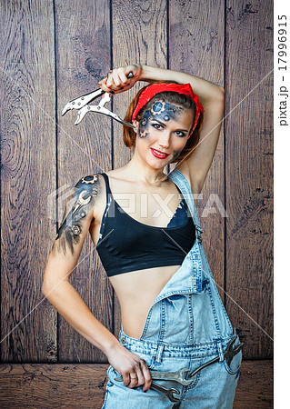 Girl mechanic with face art posing with instrument Girl mechanic with face art posing with instrument 17996915