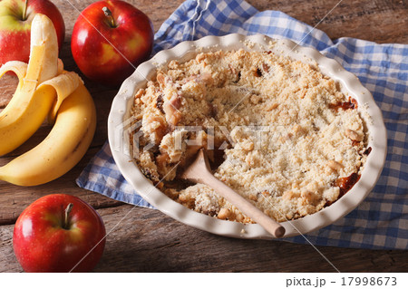 Crumble with apple and banana close-up, rustic 17998673