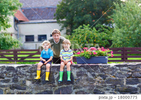dad and two little kid boys sitting together  dad and two little kid boys sitting together  18000775