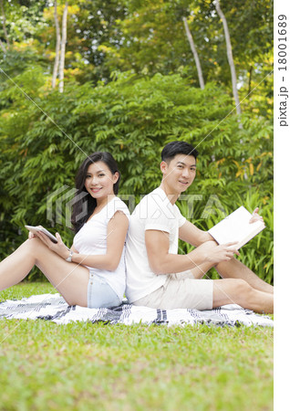 An Asian young couple dating in a park. An Asian young couple dating in a park. 18001689