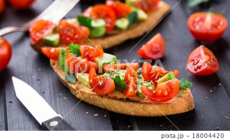 Bruschetta with tomato, avocado and herbs Bruschetta with tomato, avocado and herbs 18004420