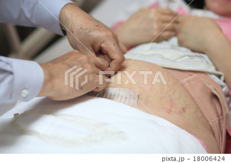 Doctor checking pregnant belly stomach 18006424