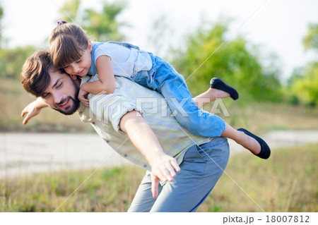 Cheerful parent and child are making fun in park 18007812