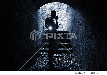 Young man with radio set and flashlight in tunnel 18012896