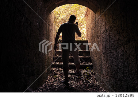 Young man with radio set in dark stone tunnel 18012899