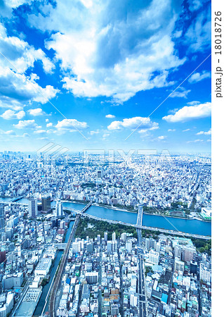 東京の都市風景 空 天空 雲 空と雲と大都会 建造物 ビル群 ビジネス コピースペース 背景素材の写真素材