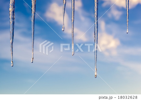 Icicles against a blue sky with clouds Icicles against a blue sky with clouds 18032628