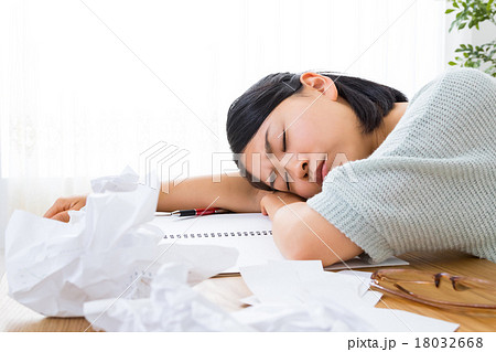 疲労困憊の女性 うたた寝 書き物 疲れた 寝ている女の人 リビングでぐったりするの写真素材