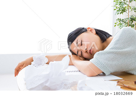 疲労困憊の女性 うたた寝 書き物 疲れた 寝ている女の人 リビングでぐったりするの写真素材