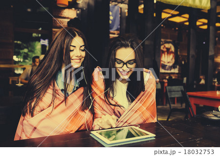 two close friends watching something on a tablet two close friends watching something on a tablet 18032753