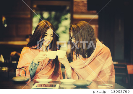 Two young and beautiful girls gossiping 18032769