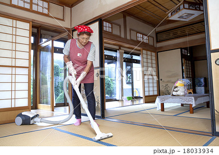 和室に掃除機をかける中年女性 18033934