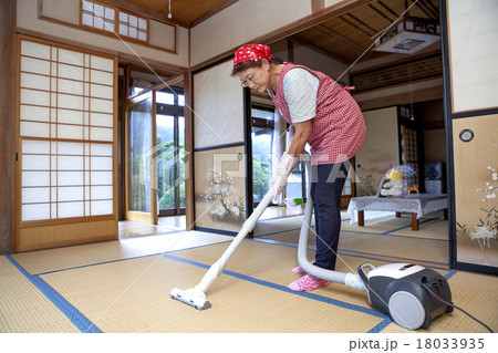 和室に掃除機をかける中年女性の写真素材