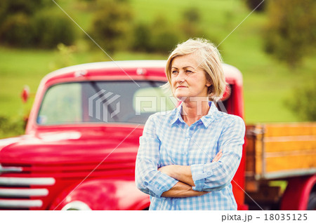 Senior woman with red car Senior woman with red car 18035125