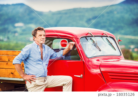 Senior man with red car Senior man with red car 18035126