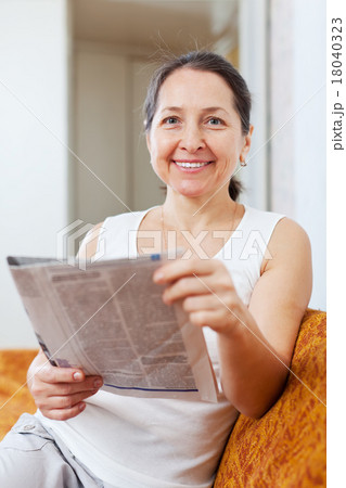positive mature woman with fresh newspaper 18040323