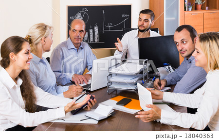 colleagues discussing price development at office colleagues discussing price development at office 18040363
