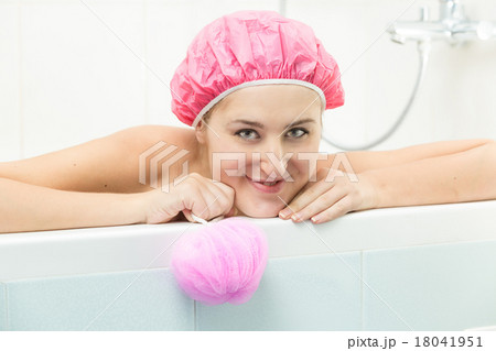 smiling woman lying in bath and looking at camera 18041951