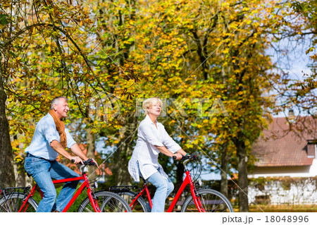 Seniors on bicycles having tour in park 18048996