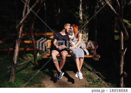 beautiful couple together with dog on a swing beautiful couple together with dog on a swing 18058688