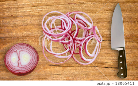 knife on cutting board and sliced red onion 18065411