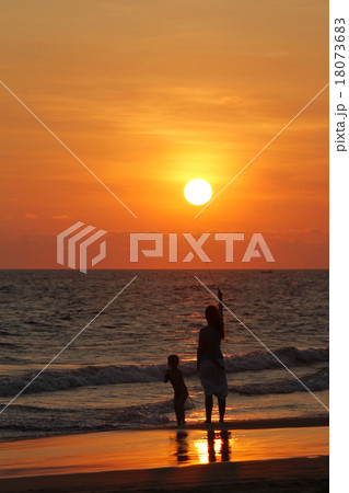太陽にタッチ ビーチで遊ぶ親子 ヒッカドゥワの夕陽 スリランカの海岸 太陽にタッチ ビーチで遊ぶ親子 ヒッカドゥワの夕陽 スリランカの海岸 18073683