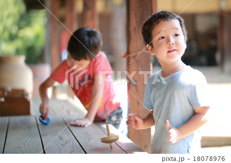コマで遊ぶ子供 18078976