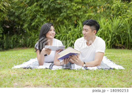 A young couple exchanging reading materials. 18090253