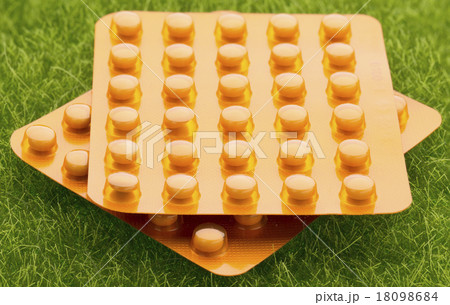 Set of orange pill blister pack on grass 18098684