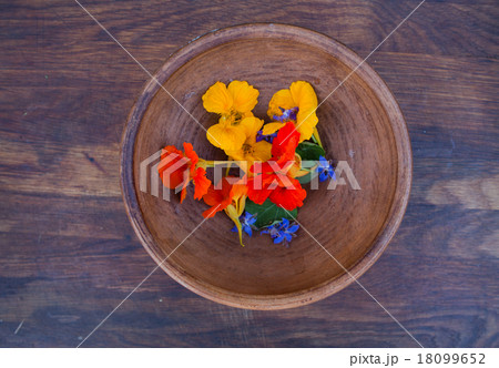 Colorful edible flowers in clay bowl Colorful edible flowers in clay bowl 18099652