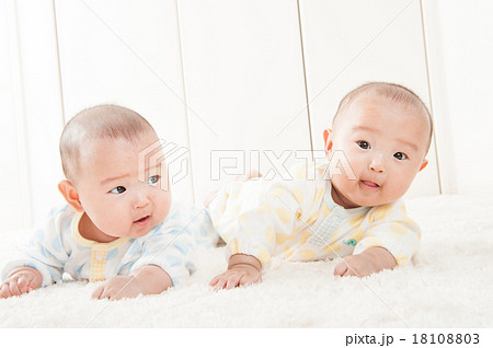双子の赤ちゃんのハイハイの写真素材