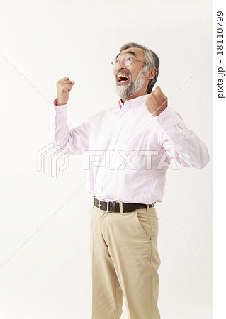 両手ガッツポーズで叫ぶシニア男性の写真素材