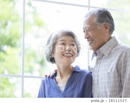 窓辺で寄り添うシニア夫婦 18111527