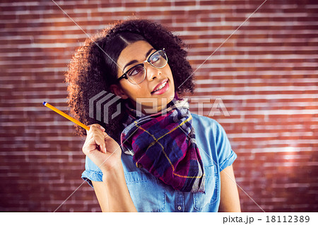 Daydreaming attractive hipster holding pen 18112389