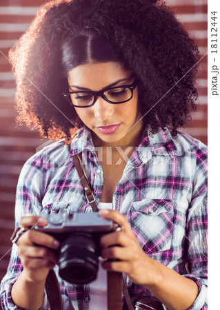 Attractive hipster looking at photos on camera 18112444